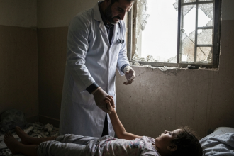 Profissional de saúde em Gaza cuidando de paciente ferido.