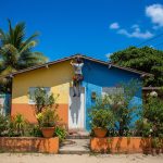 Casa de praia com piscina e jardim ensolarados.