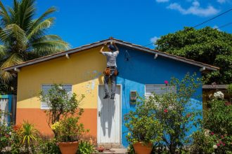 Casa de praia com piscina e jardim ensolarados.