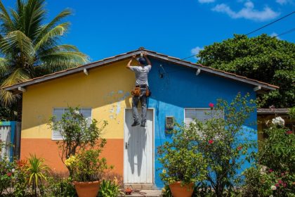 Casa de praia com piscina e jardim ensolarados.